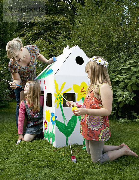 Mama und Mädchen spielen mit dem Wendy House.