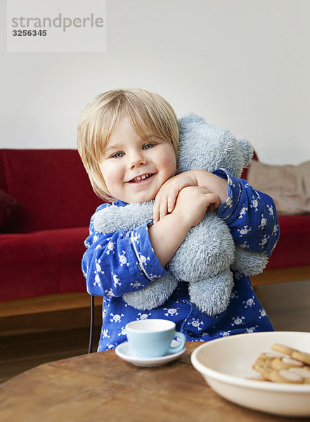 Ein Junge  der seinen Teddybären kuschelt.