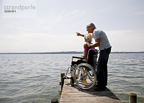 älterer Mann und Frau im Rollstuhl