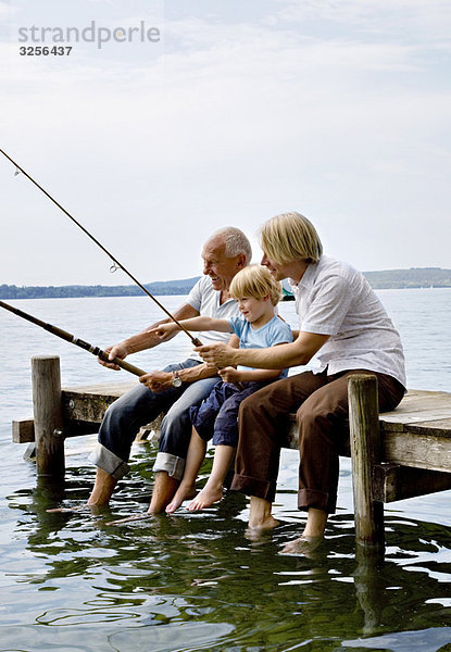 Junge fischend mit Großvater  Vater