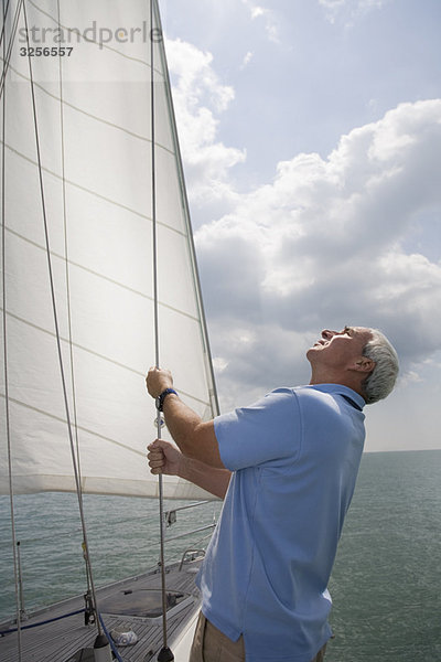 Reifer Mann beim Segeln auf der Yacht