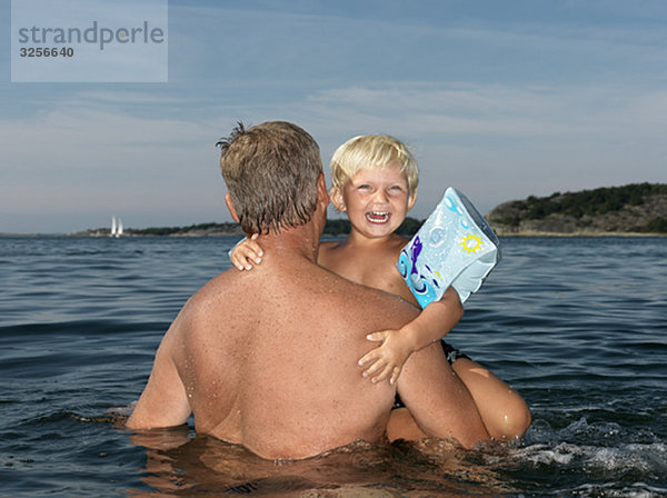 Großvater und Junge spielen im Wasser