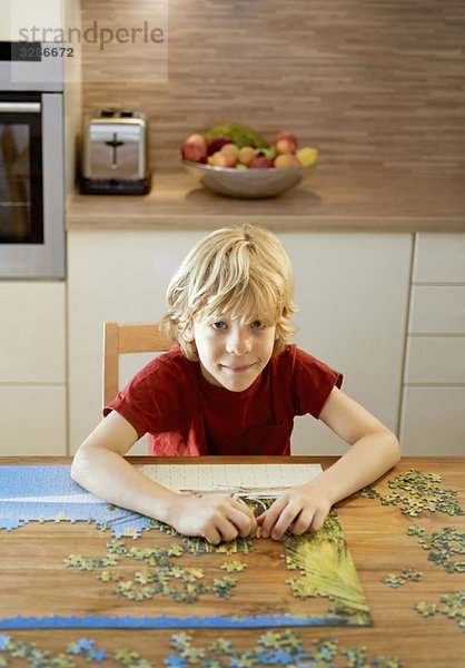 Porträt eines Jungen bei einem Puzzle