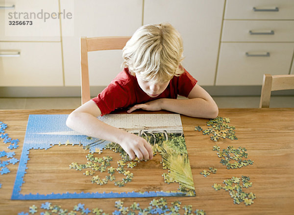 Porträt eines Jungen bei einem Puzzle