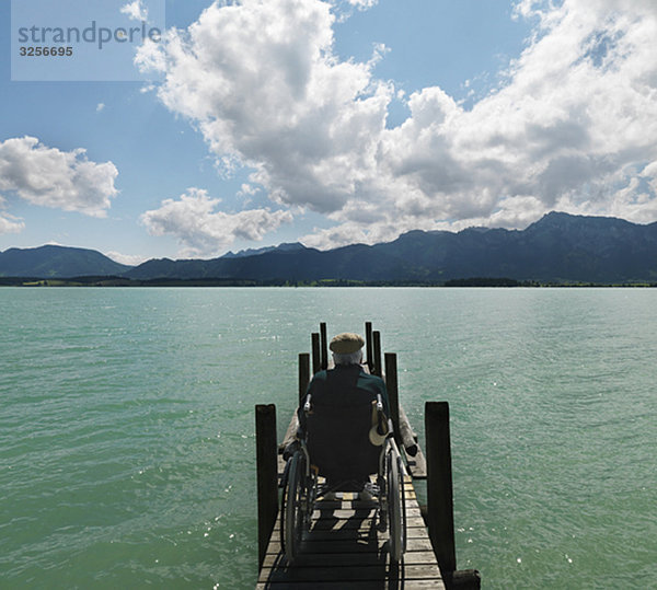 Senior im Rollstuhl am See