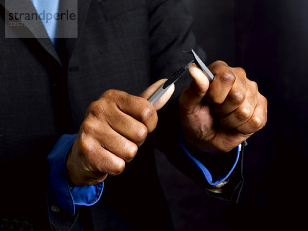 Geschäftsmann bricht Bleistift in zwei Hälften