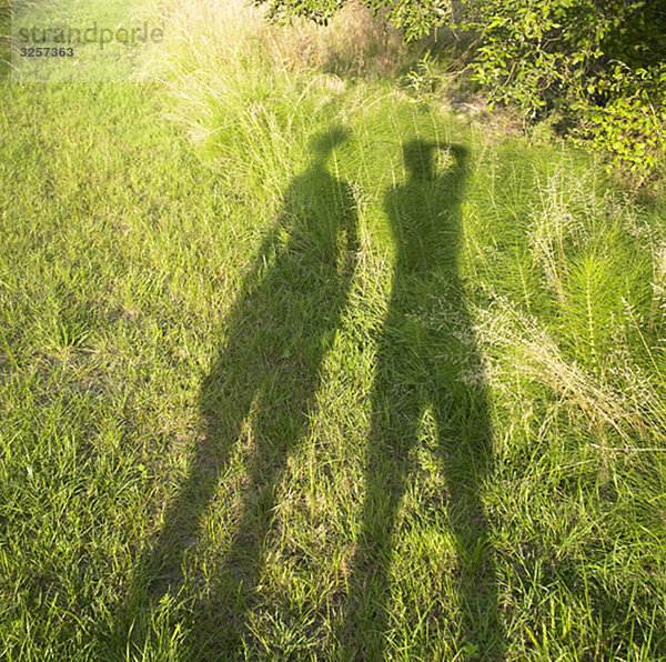 Schatten von zwei Personen auf Gras