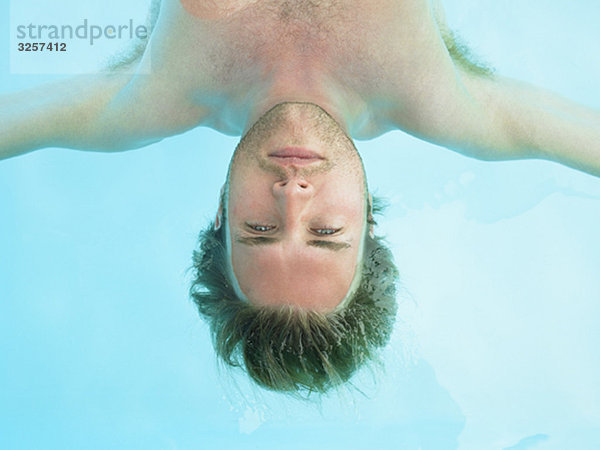 junger Mann  der im Wasser schwimmt