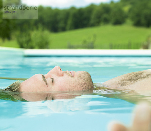 junger Mann  der im Wasser schwimmt