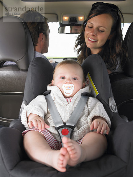 Mutter beobachtet Baby im Autositz