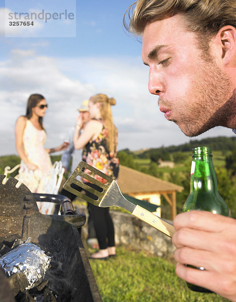 junger Mann beim Grillen