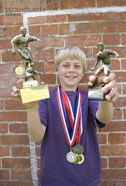 Kinderfußballer mit Medaillen und Trophäe