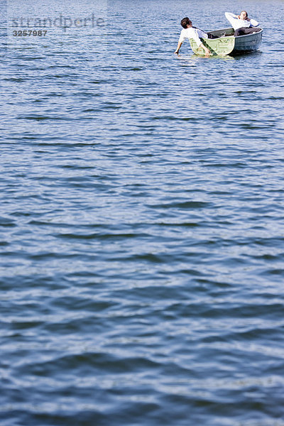 zwei Geschäftsleute  die sich im Ruderboot entspannen