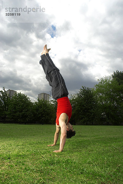 Mann beim Handstand im Park