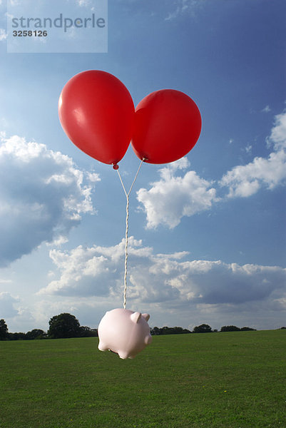 Spardose an Luftballons gebunden