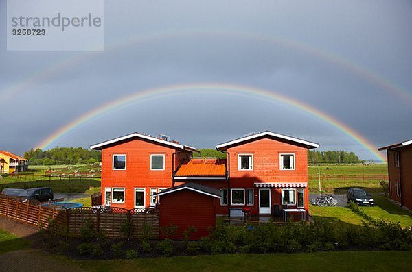 Rainbow over houses  Sweden.