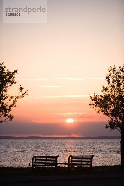 Zwei Parken Bänke in den Sonnenuntergang am Meer  Schweden.