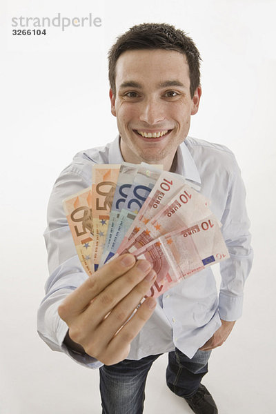 Geschäftsmann mit Euro-Scheinen  lächelnd  Portrait