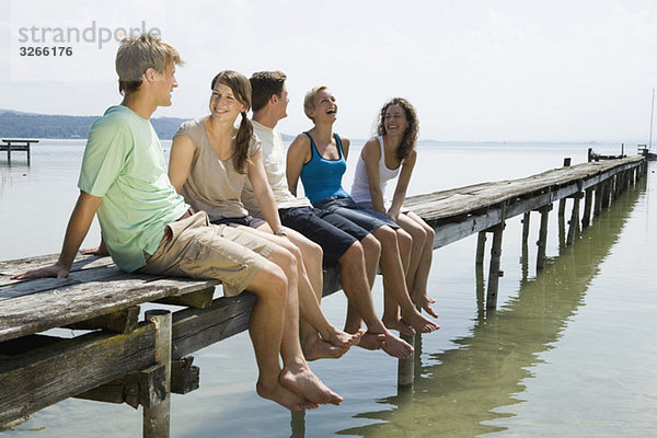 Germany  Bavaria  Ammersee  Young people relaxing on jetty