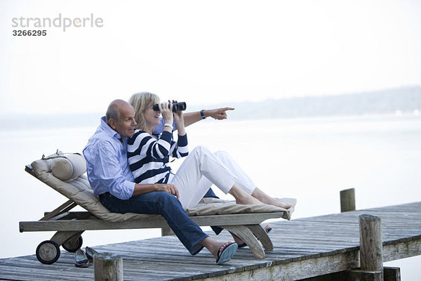 Starnberger See  Seniorenpaar auf Sonnenliege  Frau durchs Fernglas schauend