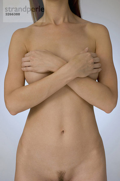 Nackte Frau  die ihre Brüste bedeckt