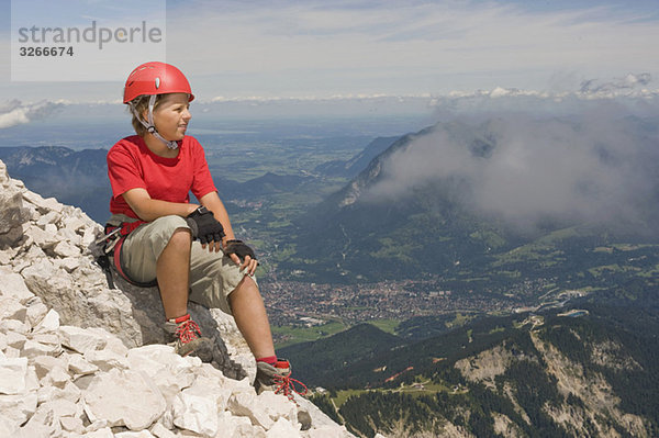 Bergsteiger  Junge (12-13) sitzend auf dem Gipfel  Portrait