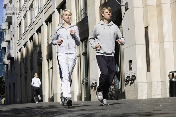Germany  Berlin  Young couple jogging together