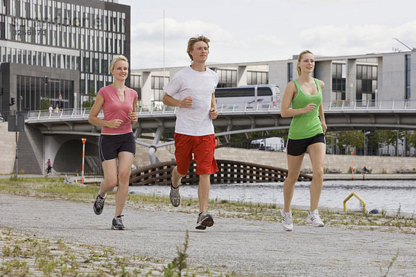 Deutschland  Berlin  Drei Freunde joggen in der Stadt