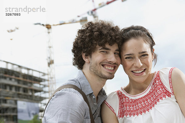 Deutschland  Berlin  Junges Paar vor dem Neubau  Krane im Hintergrund