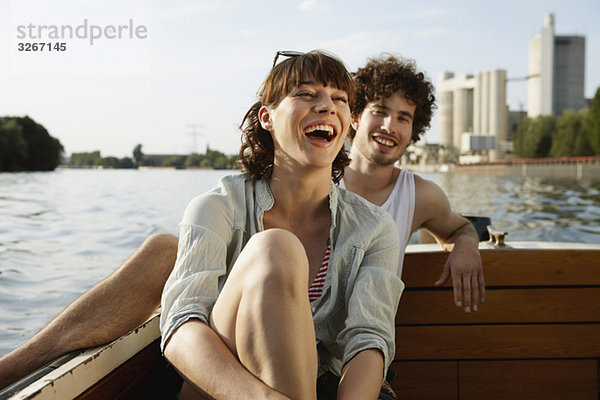 Deutschland  Berlin  Junges Paar auf Motorboot  lachend  Portrait