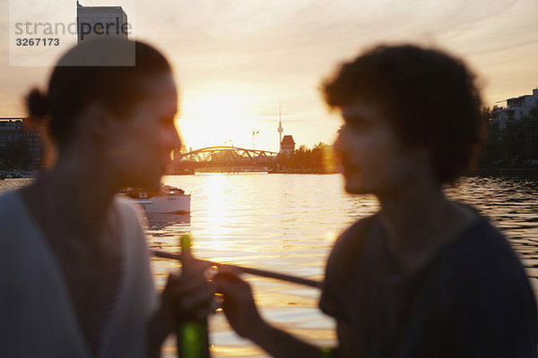 Deutschland  Berlin  Junges Paar auf dem Boot  Flaschen halten  Seitenansicht  Portrait