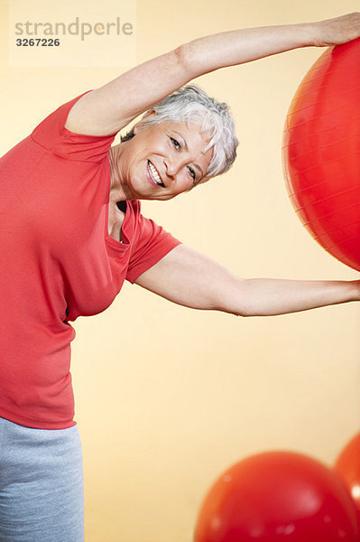 Seniorin beim Üben mit Gymnastikball