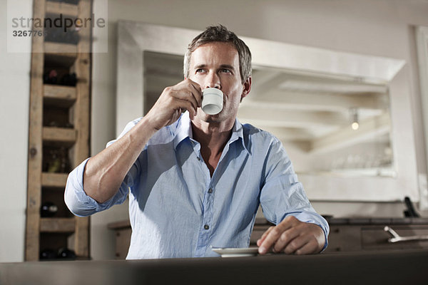 Man sitting at table  drinking cup of espresso