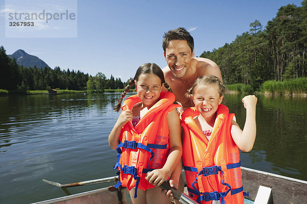 Italien  Südtirol  Vater und Kinder (6-7) (8-9)  mit Schwimmwesten  lächelnd  Porträt