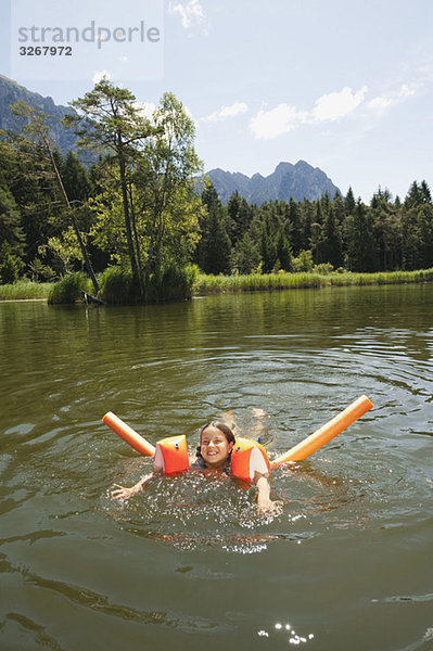 Italien  Südtirol  Mädchen (8-9) im See schwimmend  lächelnd  Portrait