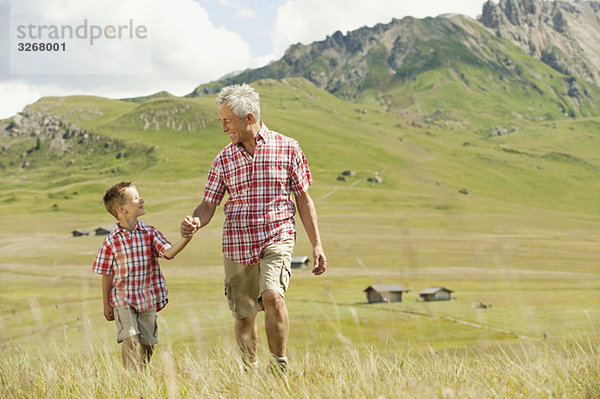 Italien  Seiseralm  Großvater und Enkel (6-7) beim Wandern im Feld