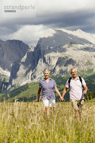 Italien  Seiseralm  Seniorenpaar Wandern Hand in Hand