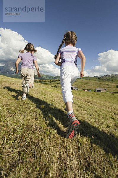 Italien  Seiseralm  Mädchen (6-9) auf der Wiese  Rückansicht