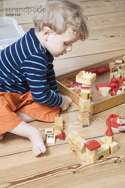 Junge (2-3) spielt mit Bausteinen