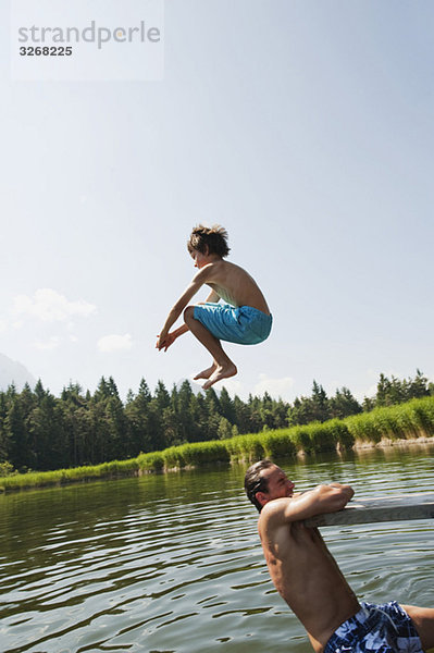 Italien Südtirol  Vater und Sohn (10-11)  Sohn springt in den See