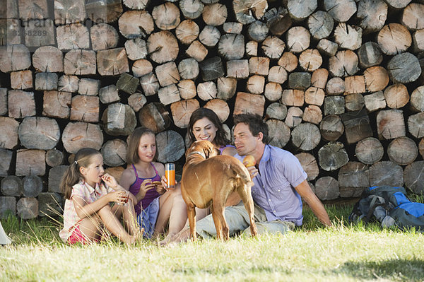 Italien  Südtirol  Familie beim Picknick vor Holzhaufen
