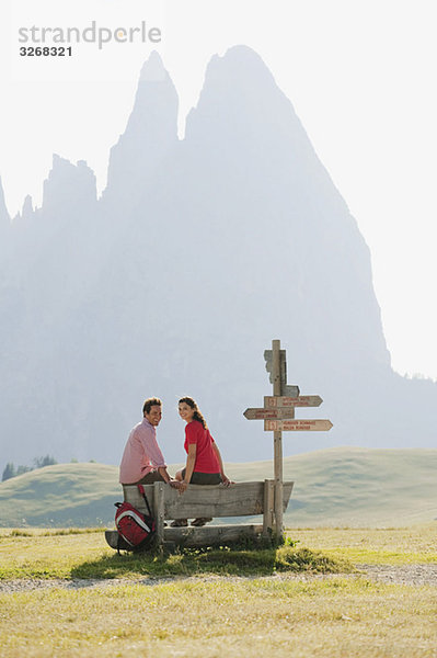 Italien  Südtirol  Seiseralm  Paar auf Bank sitzend