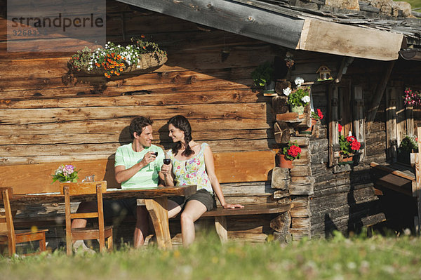 Italien  Südtirol  Paar vor der Blockhütte Wein trinken  Portrait
