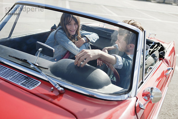 Deutschland  Berlin  Junges Paar im Cabriolet sitzend  lächelnd  Portrait