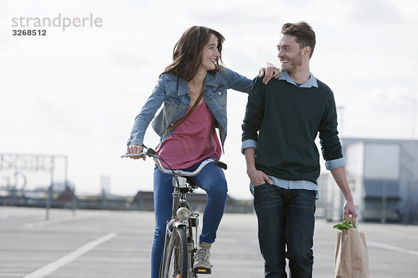 Deutschland  Berlin  Junges Paar mit Fahrrad und Papiertüte