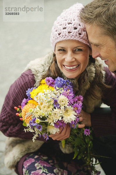 Paar  Frau hält Blumenstrauß  lächelnd  Portrait