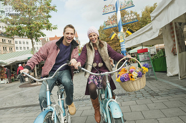 Deutschland  Bayern  München  Viktualienmarkt  Paar mit Fahrrädern  lachend  Portrait