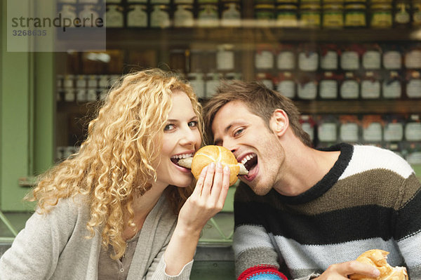 Deutschland  Bayern  München  Junges Paar am Viktualienmarkt beim Snack  Portrait