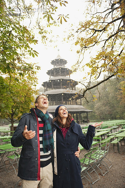 Deutschland  Bayern  München  Englischer Garten  Paar im verregneten Biergarten  Chinesischer Turm im Hintergrund  Portrait
