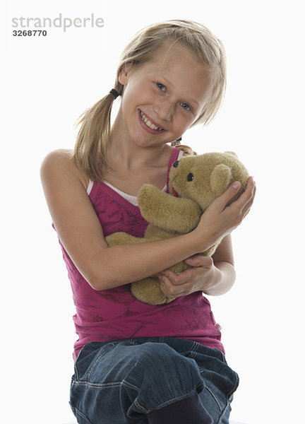 Porträt des Mädchens (10-11) kuschelnder Teddybär  Studioaufnahme